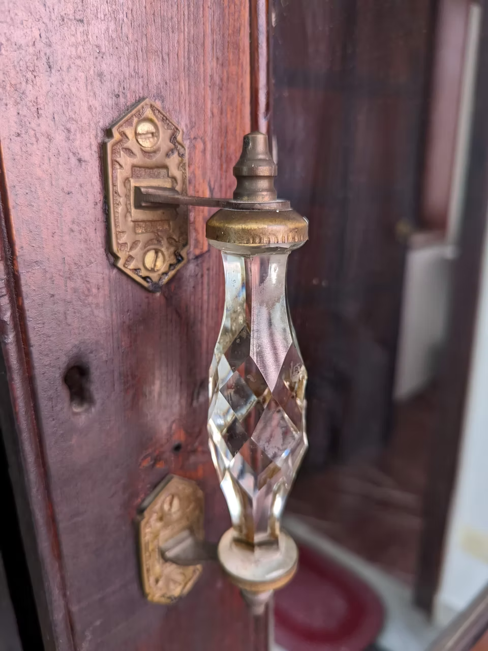A crystal and brass door handle on the original wooden door of Siddiq Manzil